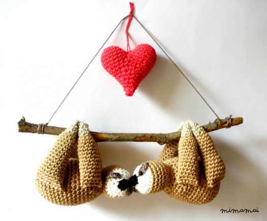 Stuffed sloths couple on a branch with red heart