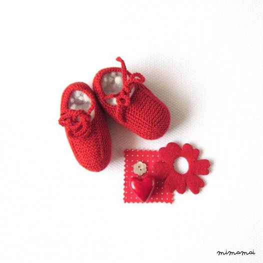 Un abito di maglia bambino in rosso con un cuore. 100% cotone.