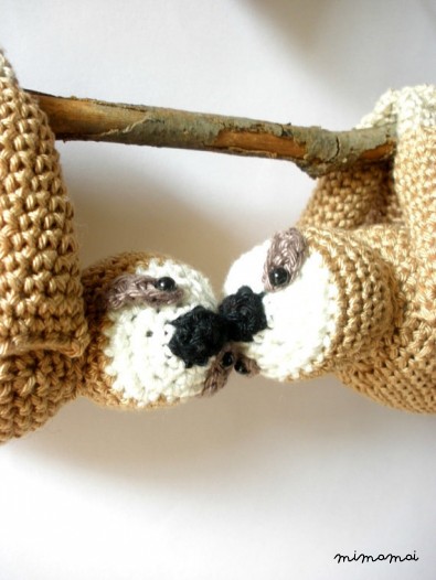 Stuffed sloths couple on a branch with red heart