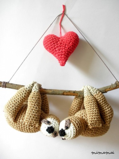 Stuffed sloths couple on a branch with red heart